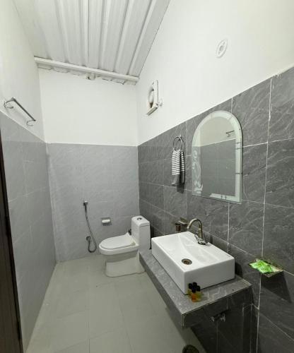 a bathroom with a sink and a toilet and a mirror at Sukoon in Nainital