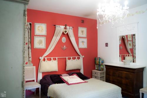 a bedroom with a bed with a red wall at Bastide de Valvérane in Manosque