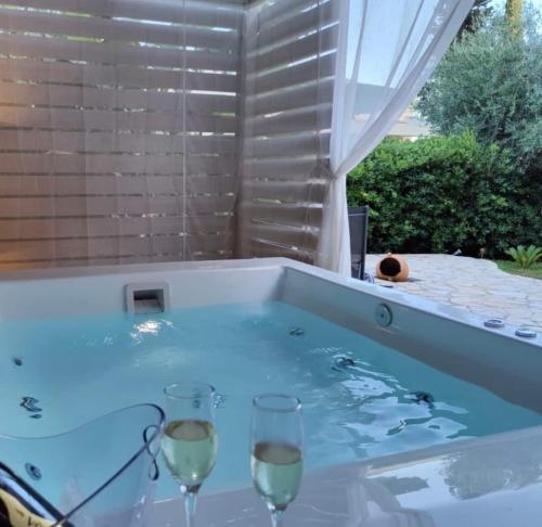 two glasses of wine in a hot tub at Nefeli Beach Home with Hot Tub - 100m to Beach in Barbati