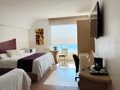 a hotel room with two beds and a desk at Hotel Magico Inn in Cuautla Morelos