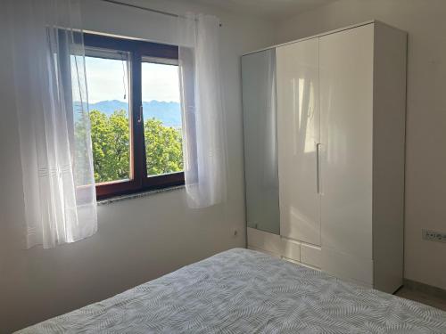 a white room with a bed and a window at Pag House in Pag