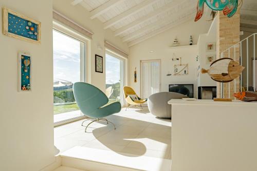 a living room with two chairs and a fireplace at Villa dei Gruccioni - YourPlace Abruzzo in Torino di Sangro