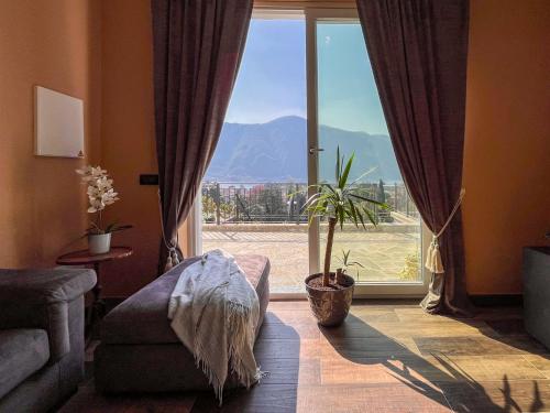 ein Wohnzimmer mit einem großen Fenster mit Aussicht in der Unterkunft Villa Lenis - Panoramic Pool in Mandello del Lario