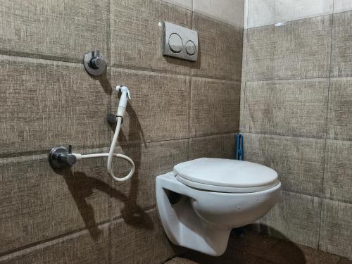 a bathroom with a white toilet in a stall at coorg mantion homestay in Madikeri