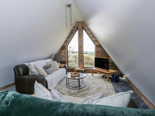 a living room with a couch and a tv at Valley View Hideaway in Llandysul