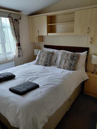 a bedroom with a large bed with white sheets and pillows at Holiday Home in Forfar