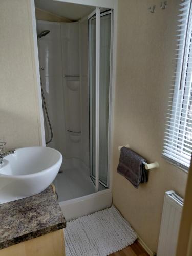 a bathroom with a shower and a white sink at Holiday Home in Forfar