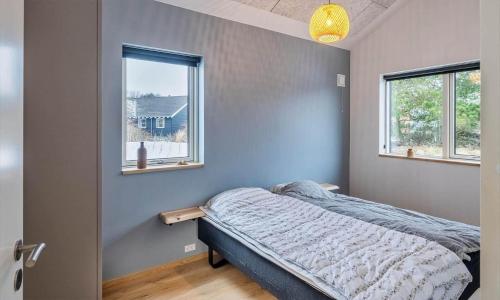 a bedroom with a bed and two windows at VE250-Vejers-Strand-Engesovej-56 in Vejers Strand