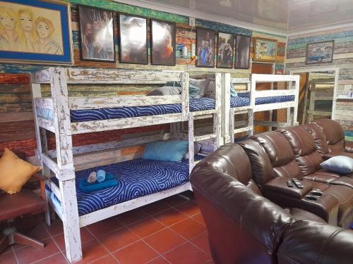 a living room with two bunk beds and a leather couch at Stadion Sleepover Cabin in Sasolburg