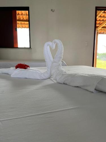 two swans making a heart on a bed at Pousada Recanto da Mãezinha in Beberibe