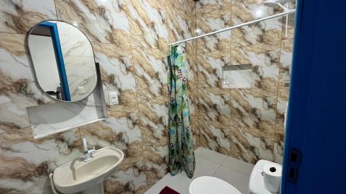 a bathroom with a sink and a mirror at Vale das Rainhas Pousada Santo Amaro BA in Santo Amaro