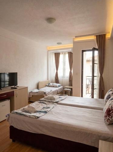 a hotel room with two beds and a television at Apartmani Marija in Ohrid