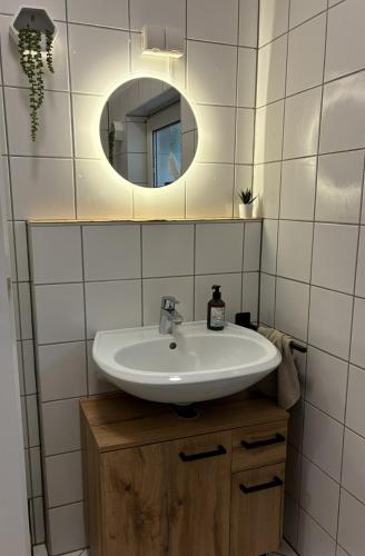 a bathroom with a sink and a mirror at Apartment am Bahnhof mit Self-Check-in in Coburg