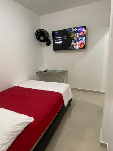 a bedroom with a bed and a tv on the wall at Apartamento Tercer Cielo 202 in Cúcuta
