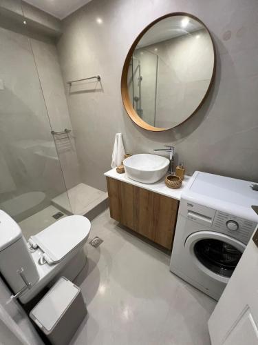 a bathroom with a washing machine and a mirror at Nice apartment close to the sea in Athens