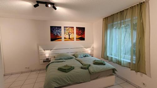 a bedroom with a bed with two green pillows on it at Ferienwohnung Waldblick in Allensbach