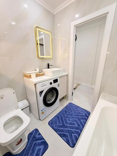 a bathroom with a toilet and a sink and a washing machine at Ulytau in Almaty