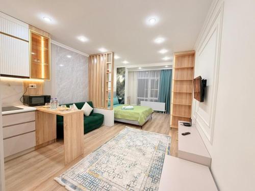 a living room with a green couch and a kitchen at Ulytau in Almaty