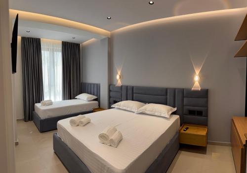 a bedroom with two beds with towels on them at Hotel Kloi - Rooms & Jacuzzi Vlore in Vlorë