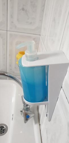 a bathroom with a sink and a blue bucket at Atlantis Place Milos in Adamantas