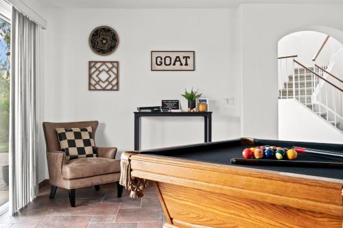 a living room with a pool table and a chair at Heated Pool 3BR Retreat Estrella Mountain in Goodyear