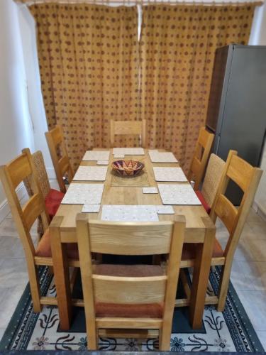 a wooden table with chairs and a bowl on top at Central to town, 4 bedrooms, sleeps 8, parking for 4 plus cars in Stratford-upon-Avon
