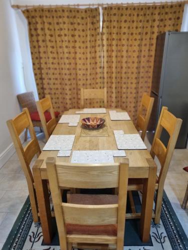 a wooden table with chairs and a bowl on top at Central to town, 4 bedrooms, sleeps 8, parking for 4 plus cars in Stratford-upon-Avon
