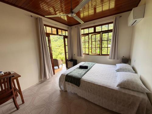 a bedroom with a large bed in a room with windows at Villa Ura in Uturoa
