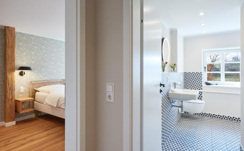 a bathroom with a sink and a bedroom with a bed at Rittergut Hirschbach in Glashütte