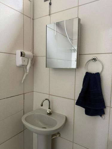 a small bathroom with a sink and a mirror at Centro de Alfenas Térreo Completo in Alfenas
