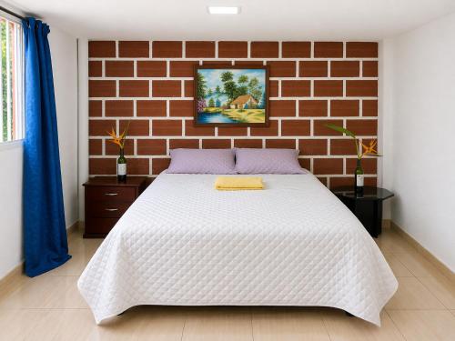 a bed in a room with a brick wall at ECOHostal Las Hamacas el colibrí in Villamaría