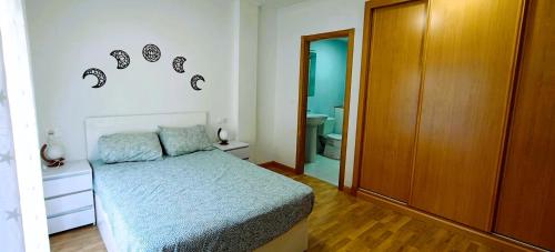 a bedroom with a bed and a bathroom at EnFOZ Terraza XXL Pet Friendly in Foz