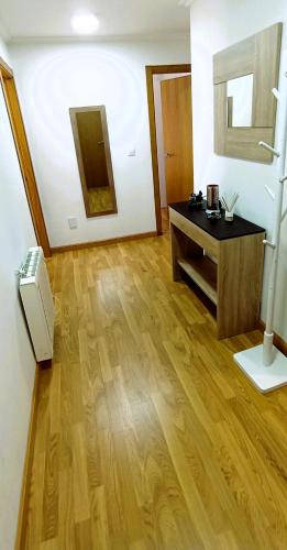 a living room with a wooden floor and a desk at EnFOZ Terraza XXL Pet Friendly in Foz