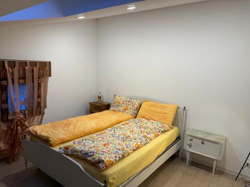 a bed in a room with a white wall at Casa Lalli in Longarone