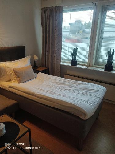 a bed in a bedroom with two windows at North Home in Skellefteå