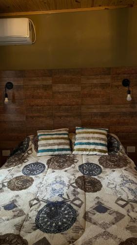 a bed with two pillows on top of it at Hospedaje Lourdes in Villa Yacanto