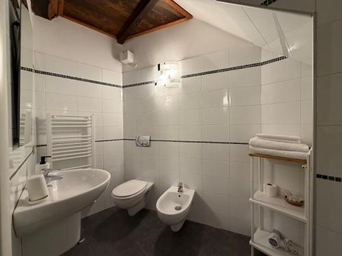 a white bathroom with a sink and a toilet at La Dolce Vita in Riomaggiore