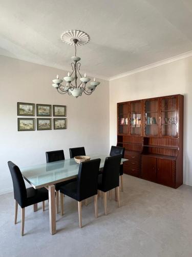 a dining room with a table and chairs and a chandelier at Spacious & Central 3-Bedroom Apartment Close to the Sea in Taʼ Xbiex