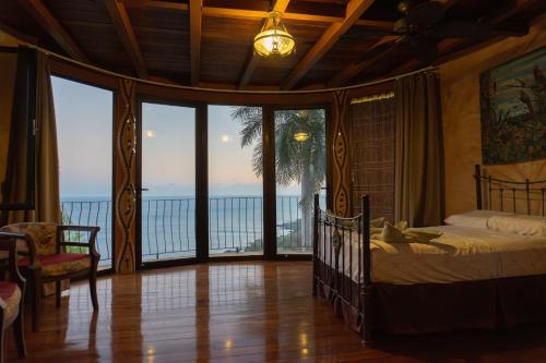 a bedroom with a bed and a view of the ocean at Montezuma Heights in Montezuma