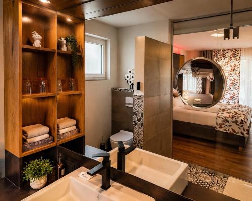 a bathroom with a sink and a mirror at KOASA HOF Bed and Breakfast in Oberhaag