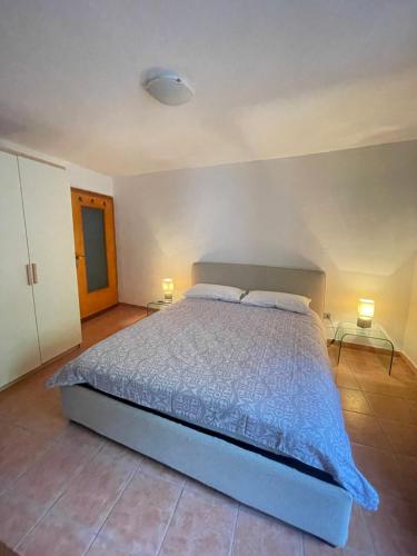 a bedroom with a bed with two lamps and two tables at Ninfea Como Lake - La casa del viandante in Bellano