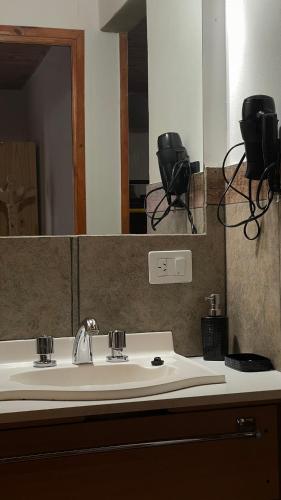 a bathroom with a sink and a large mirror at Hospedaje Lourdes in Villa Yacanto