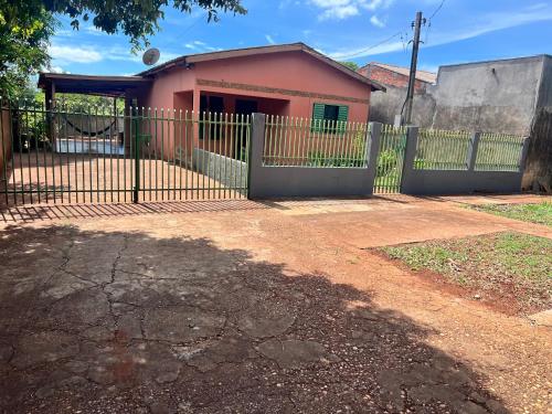 a fence in front of a pink house at Casa central in Dourados