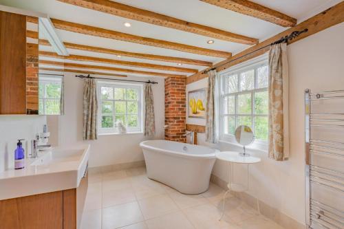 a bathroom with a tub and a sink and windows at 6 Bed in Hadlow Down oc-g36329 in Hadlow Down