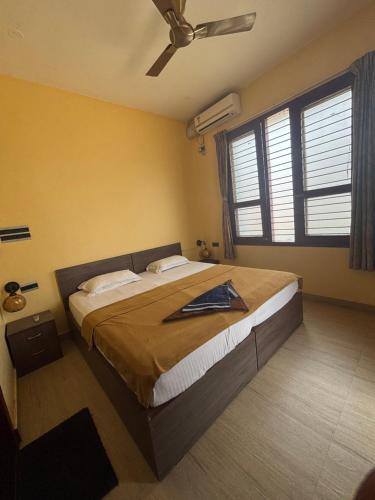 a bedroom with a large bed with a ceiling fan at Nirvana Yogashala Retreat in Mysore