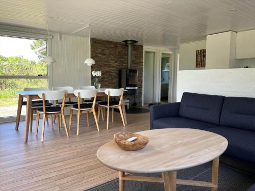 a living room with a couch and a table and chairs at VE160-Vejers-Strand-Engesovej-69 in Vejers Strand