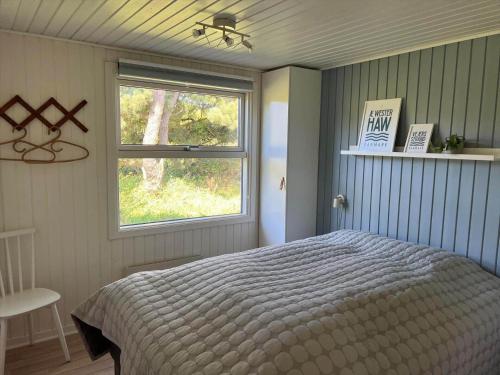 a bedroom with a bed and a window at VE160-Vejers-Strand-Engesovej-69 in Vejers Strand