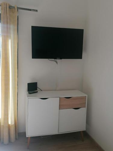 a white cabinet with a tv on a wall at Gîte d'étape Chez Isa in Vers