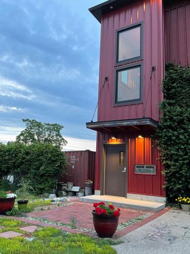 a red house with flowers in front of it at Classic Pied a Terre in Benton Harbor