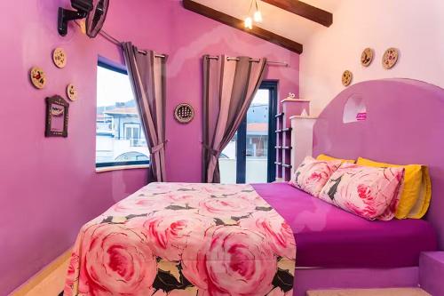 a purple bedroom with a bed with pink sheets at Villa Markella in Chrysi Ammoudia